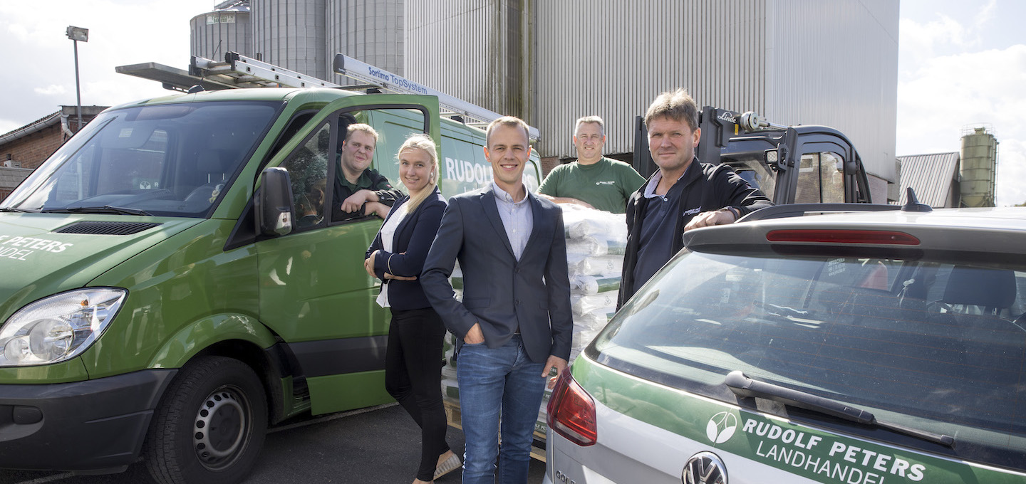 Rudolf Peters Team am Standort mit grünen Firmenfahrzeugen und sichtbarer Firmenkleidung
